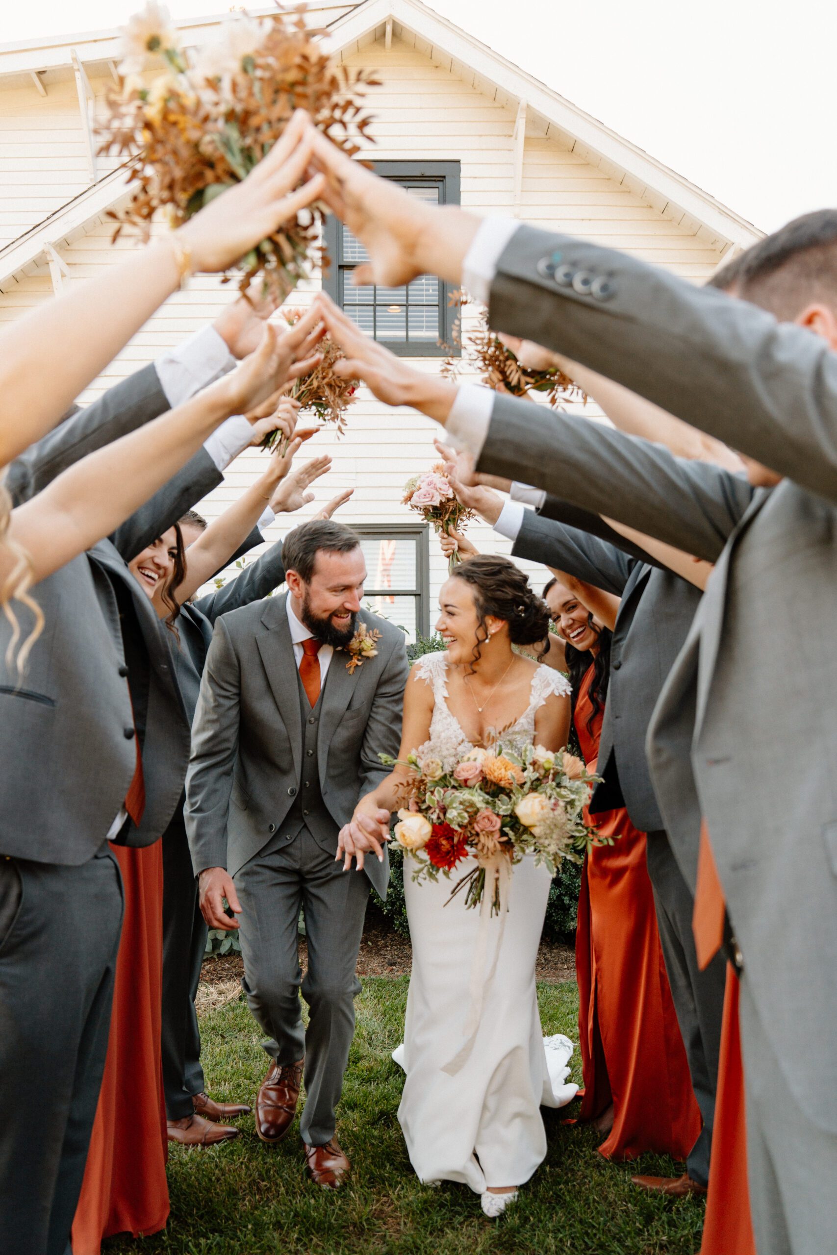 candid wedding party walking through orchard rows at Grelen in October