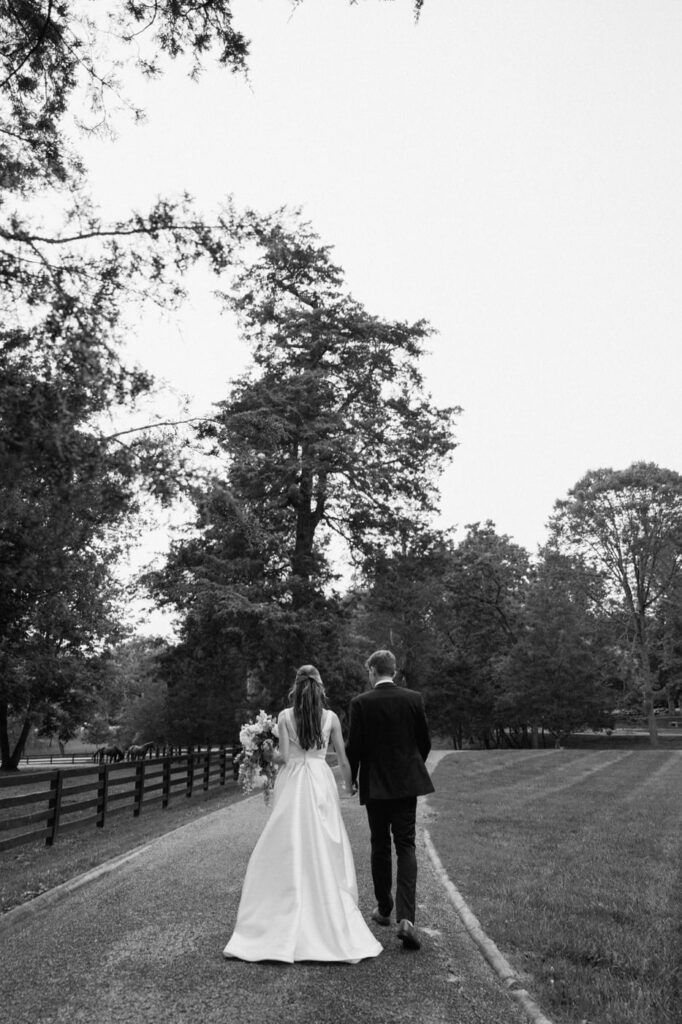 Couple walking together along a tree-lined path at Belle Meade