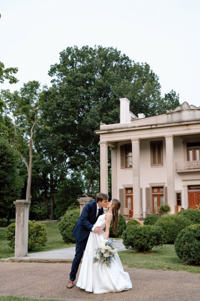 Couple kissing in front of the mansion at Belle Meade Historic Site & Winery