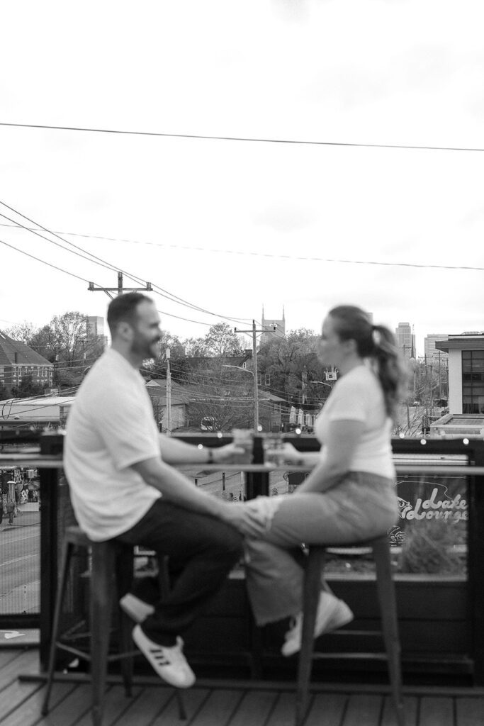 Candid moment of couple enjoying a drink at UpDown in Nashville during engagement session