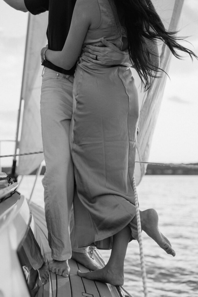 close up of the couples outfits flowing in the wind on the sailboat