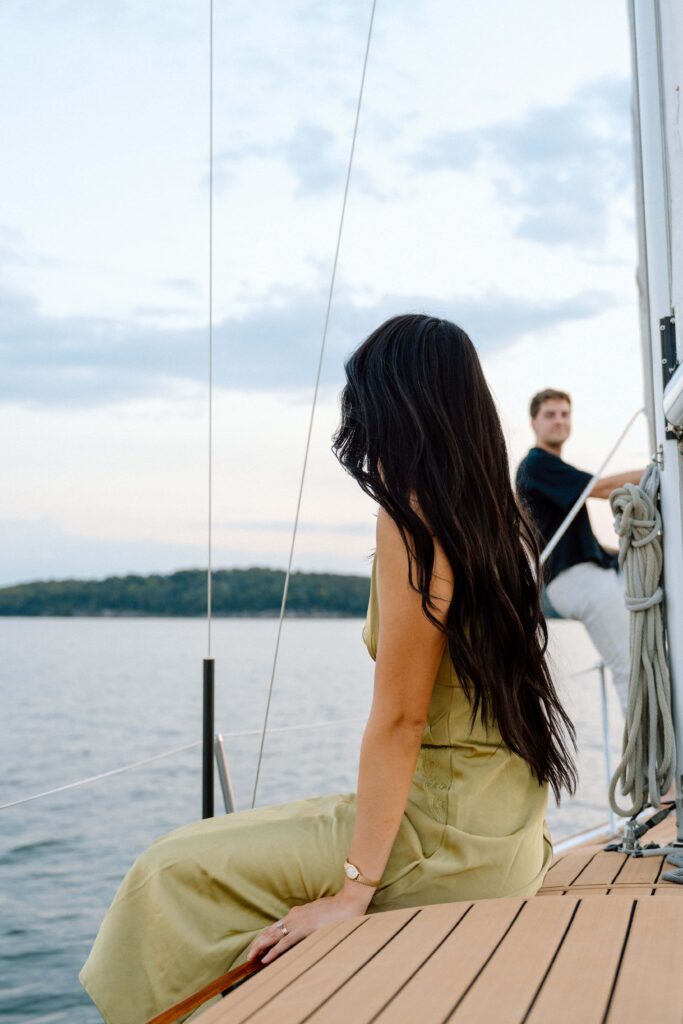 Couple sitting on a sailboat on Percy Priest Lake during sunset sailboat session