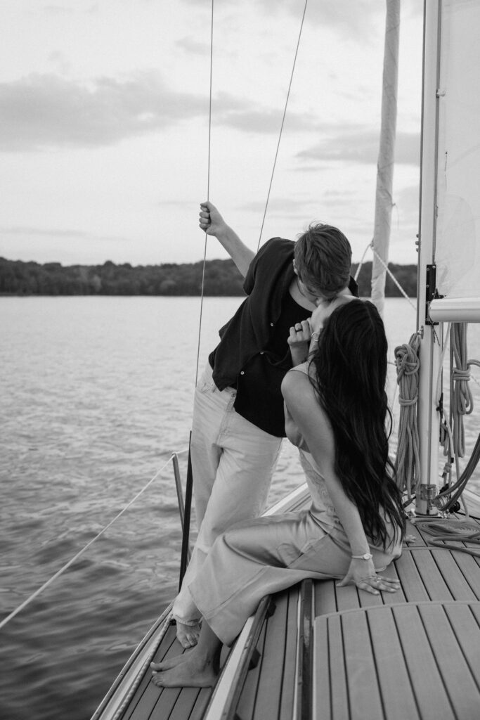 couple kissing while holding on to the rope of the sailboat on percy priest lake