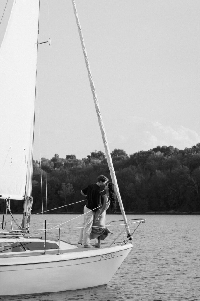 wide shot of the couple sharing a kiss on the sailboat