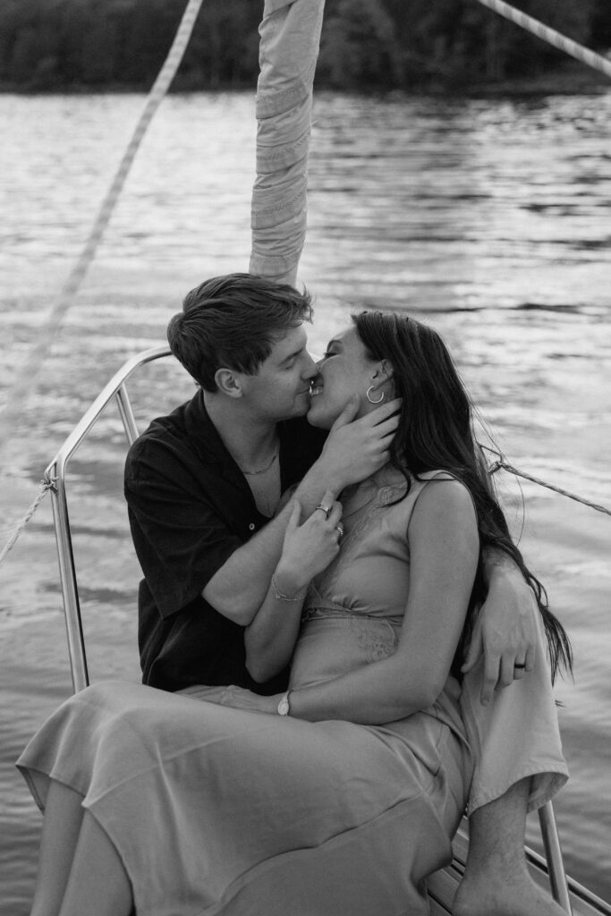 Couple leaning into each other as the sail catches wind during sunset
