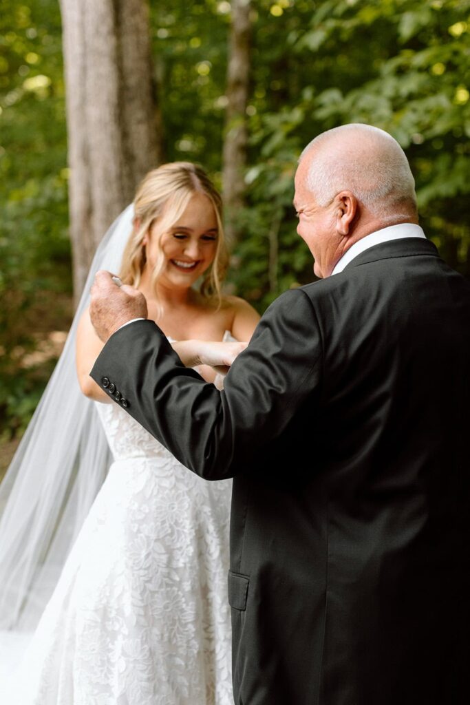 bride giving her dad a handkerchief on wedding day during their first look at the chapel at firefly lane