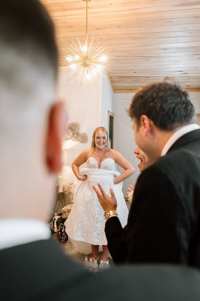 bride surprising the groomsmen with smirnoff ices during their first look