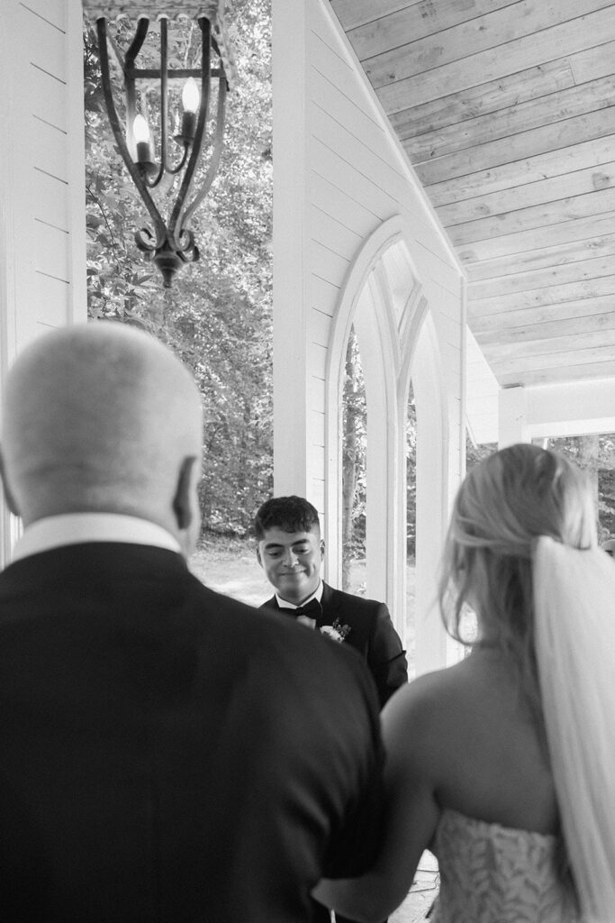 Groom seeing the bride with her father as she walks down the aisle of the chapel at firefly lane