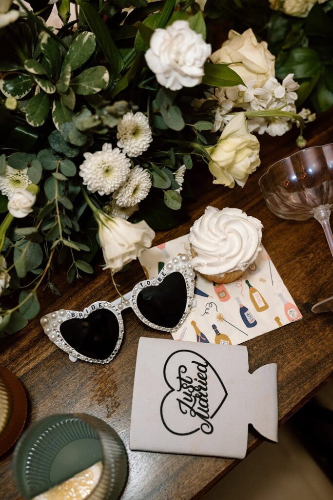 late night flat lay details of a koozie, sunglasses, cocktails, and a napkin