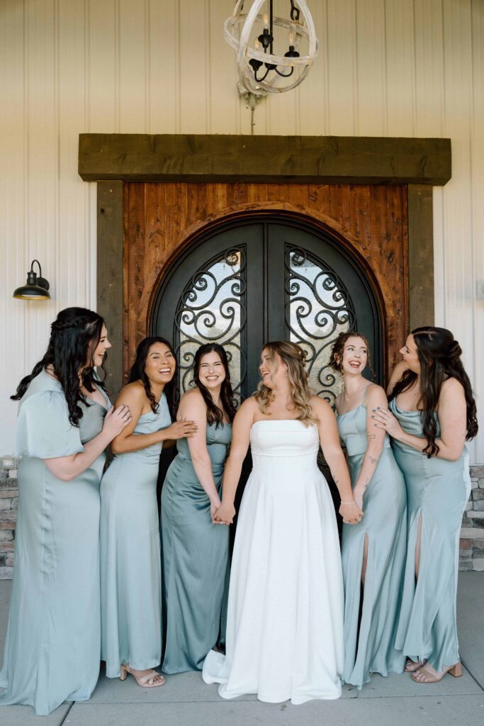 bridesmaids laughing outside the venue at fiddle dee farms in tennessee