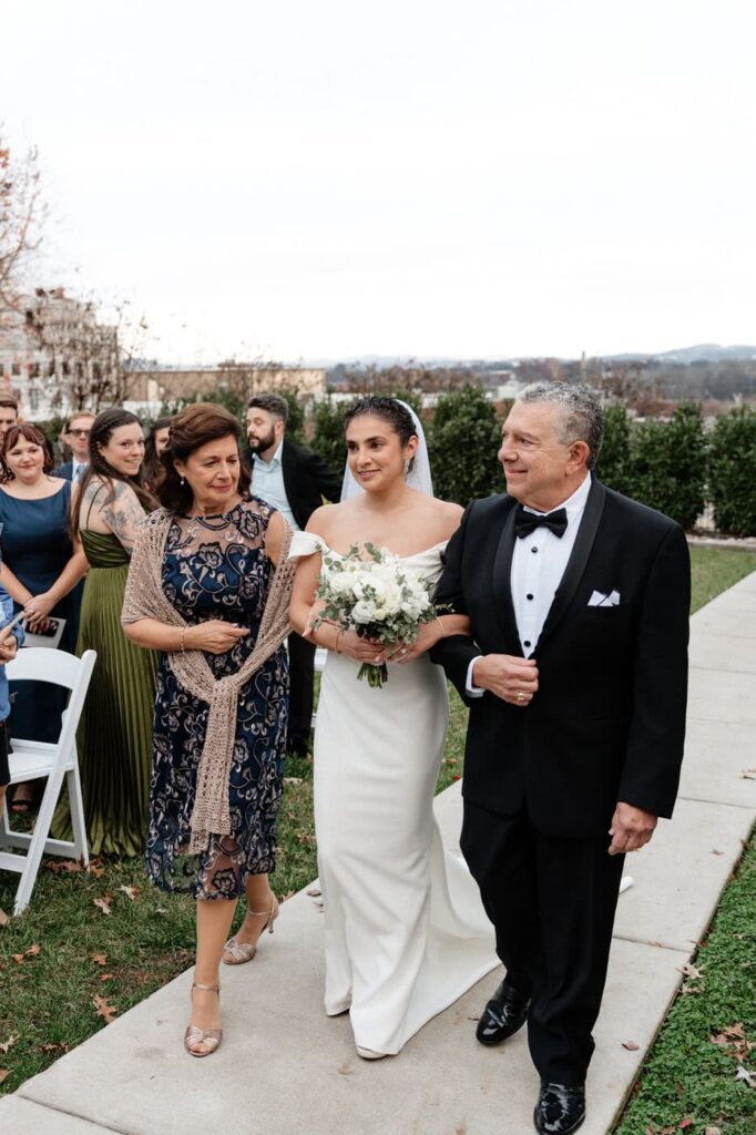 bride walking down the aisle with her parents