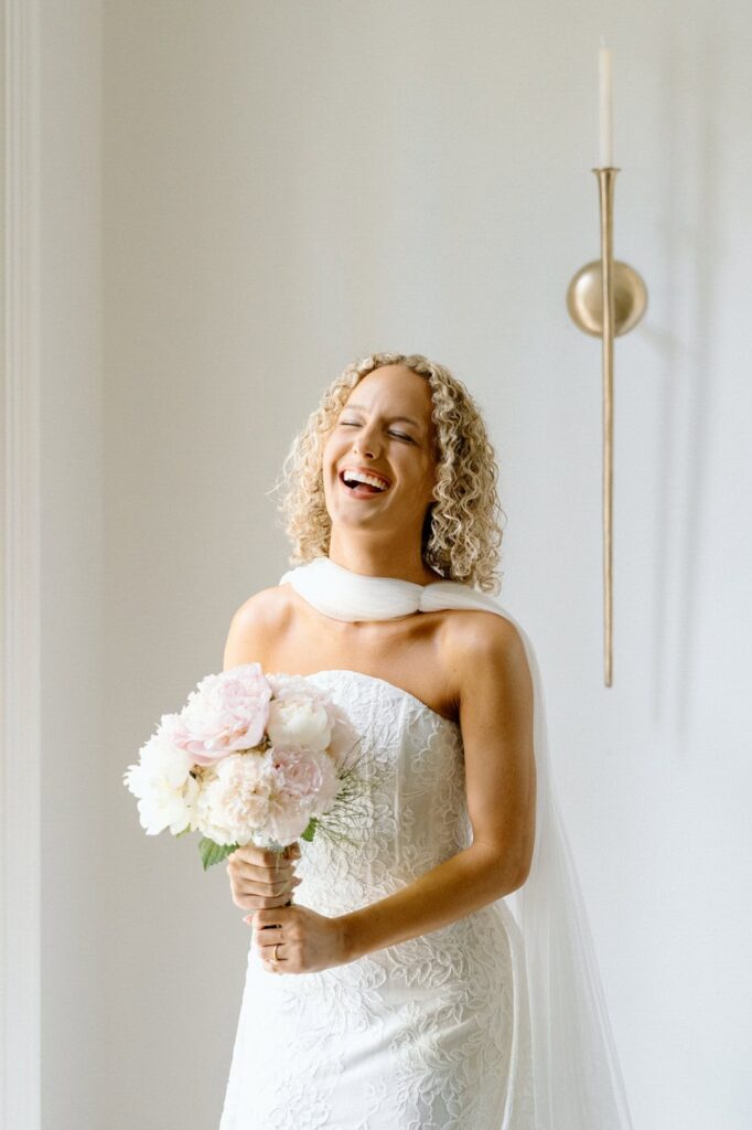 bride laughing candidly holding her bouquet during portraits