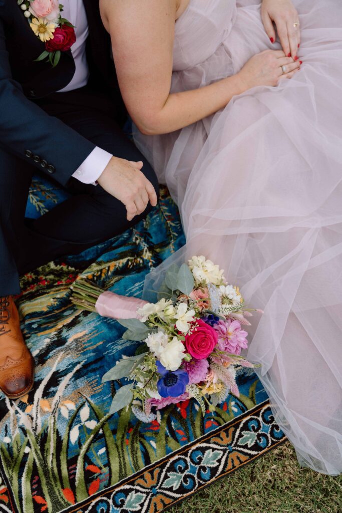 up close photo of florals and couples outfits and rug at their wedding
