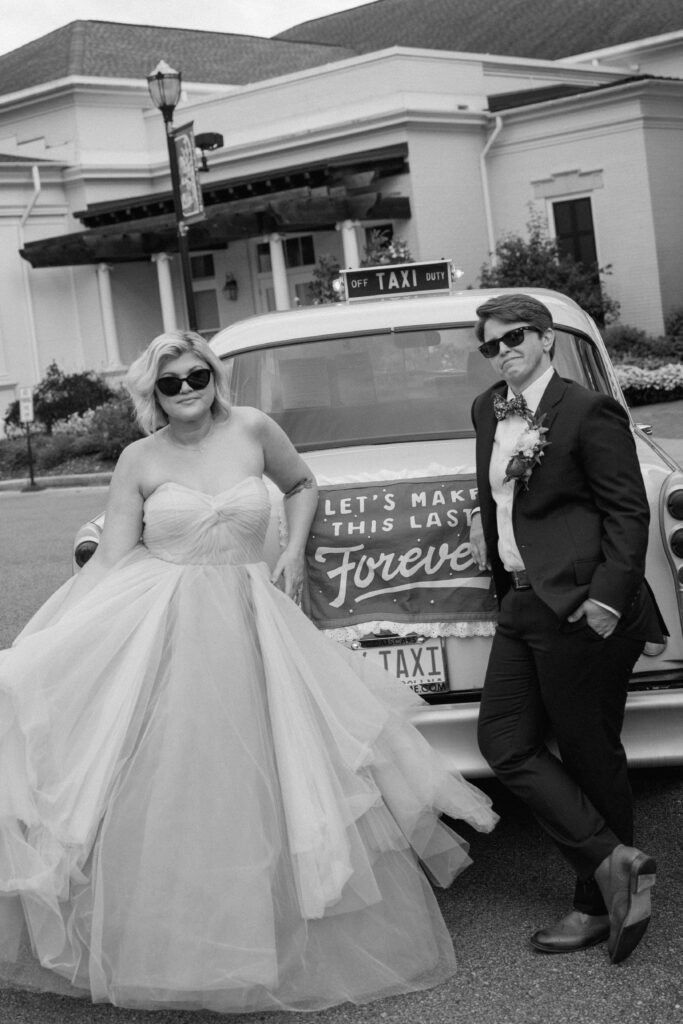 couple posing with vintage taxi cab at huntsville botanical garden in alabama