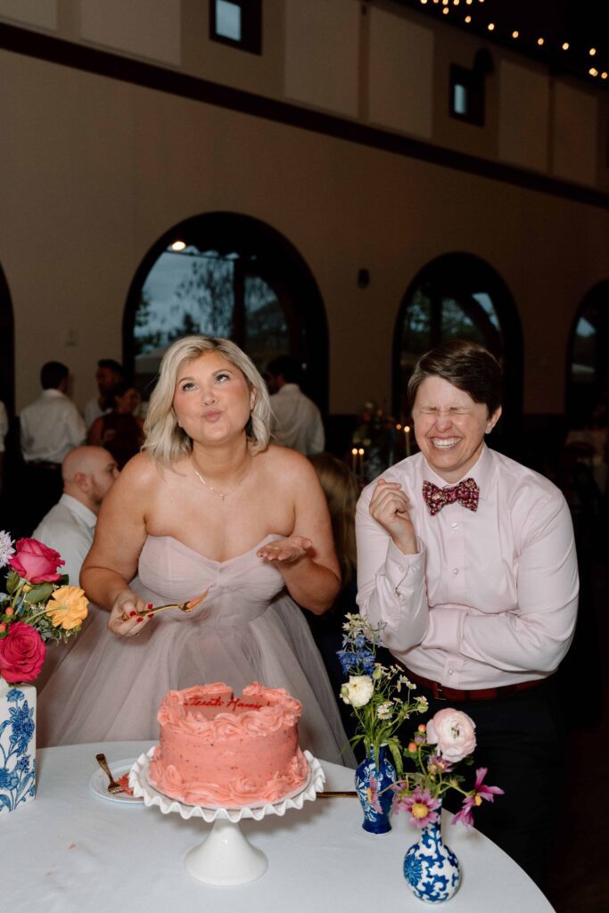 couple laughing during a candid moment at their reception while cutting the cake