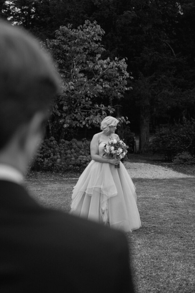 partner watching her bride take bridal photos at huntsville botanical garden wedding