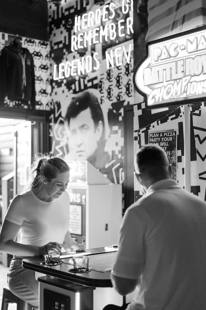 Candid moment of couple playing games during engagement session in east nashville bar