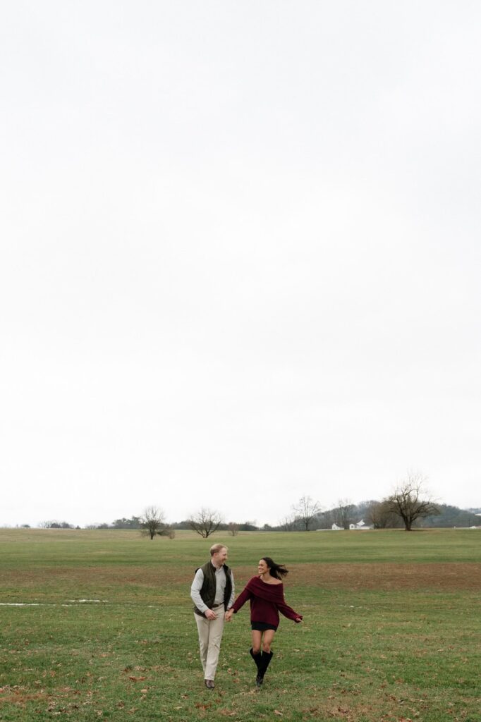 couple running through the field after proposal in franklin tennessee