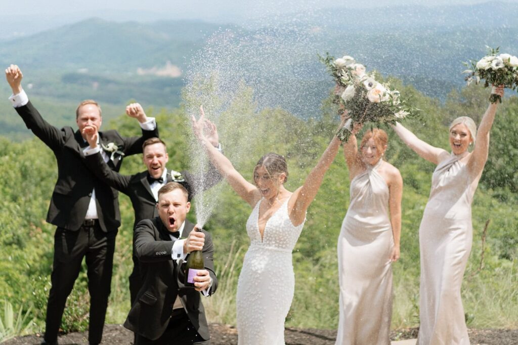 bridal party popping champagne in gatlinburg at smoky mountain wedding venue