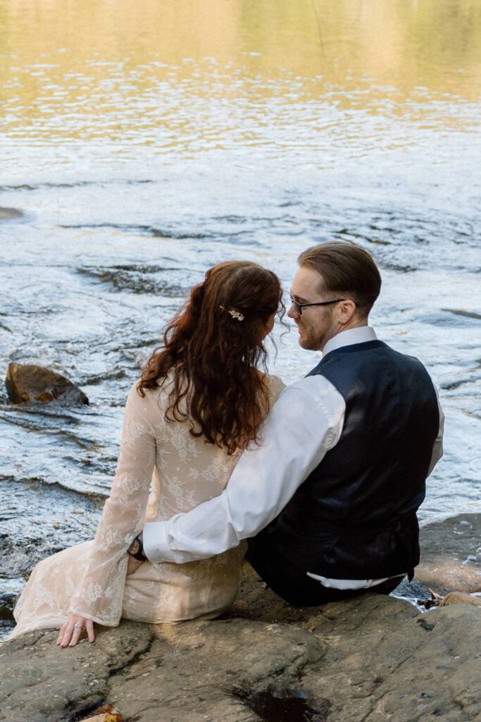 couple sitting on a rock at fall creek falls elopement in tennessee state park