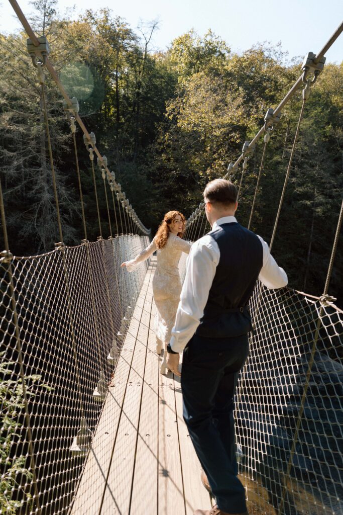 couple walking on the suspension bridge at fall creek falls elopement