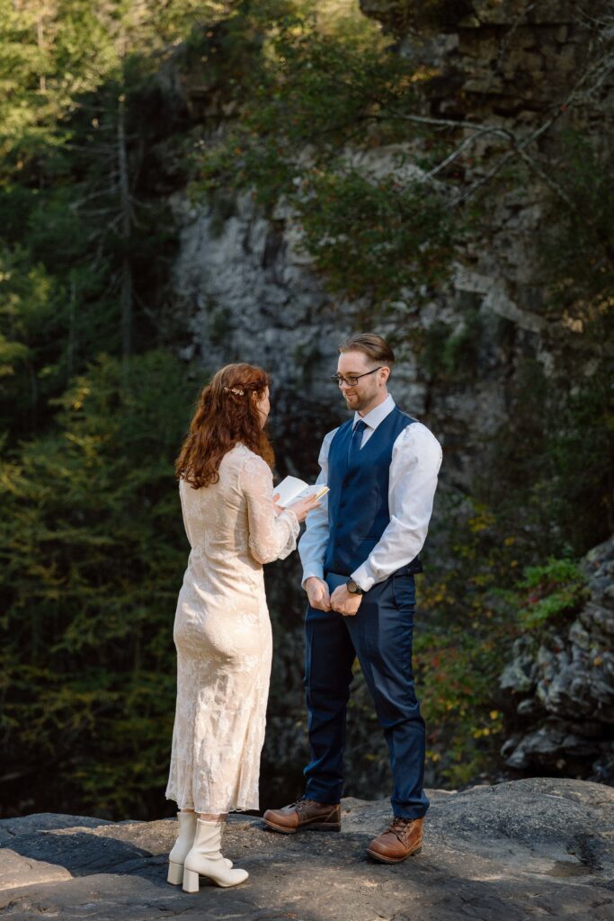couple reading vows at waterfall elopement in tennessee