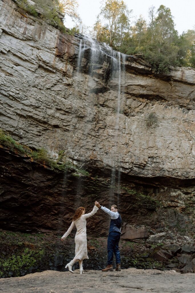 couple dancing in front of the waterfalls at their tennessee elopement
