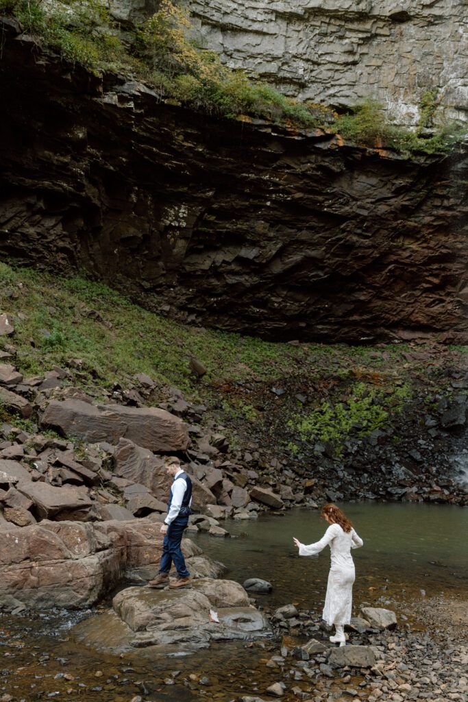 couple hiking at the base of the waterfall in tennessee state park