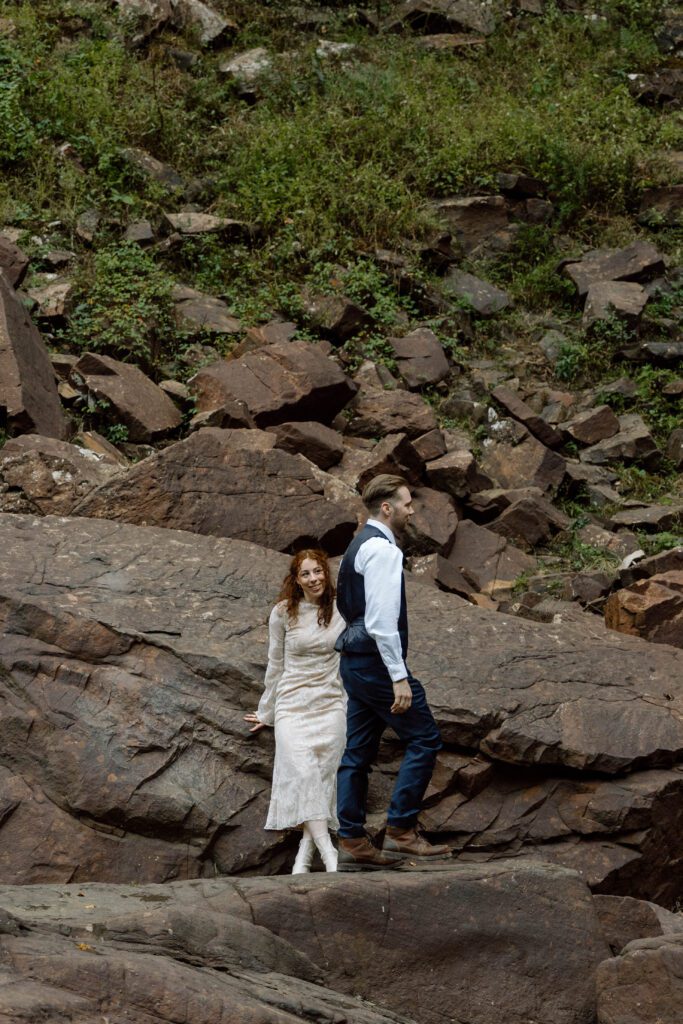 couple resting on the rocks during their waterfall elopement