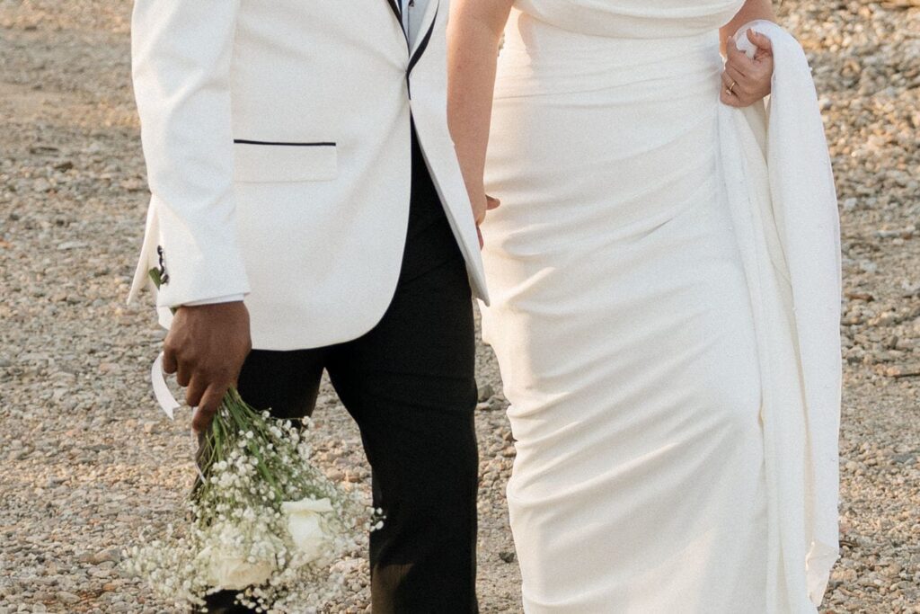 couple holding hands and walking along the street in nashville on their wedding day