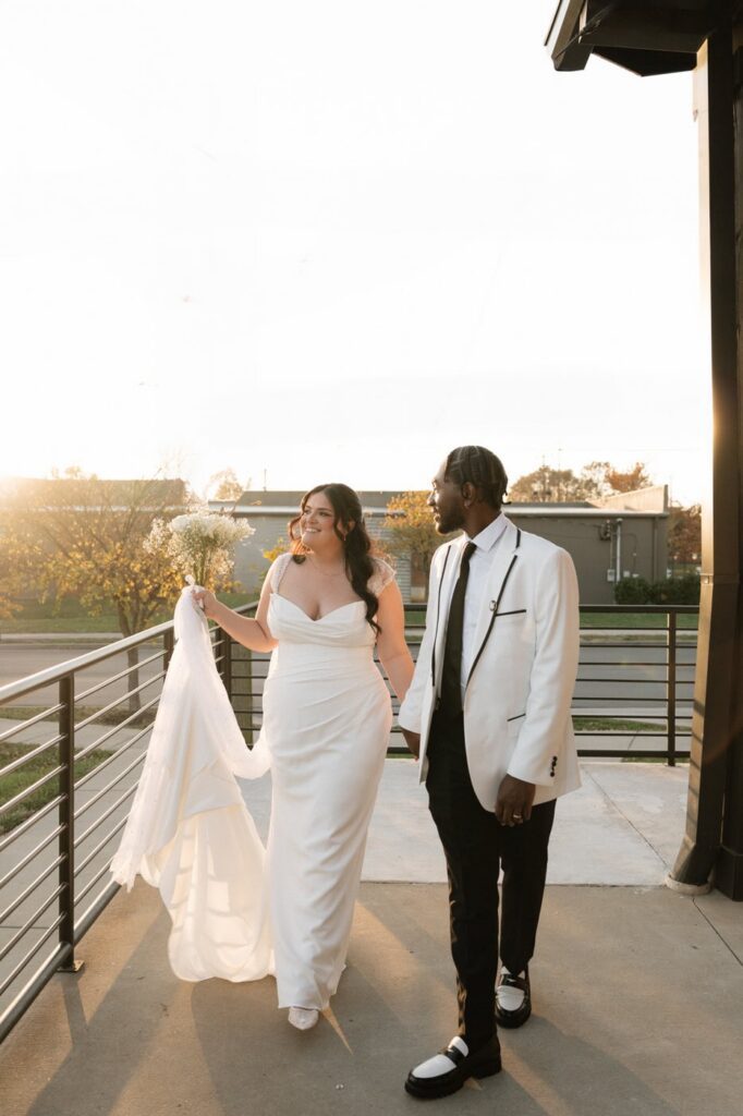 couple holding hands and laughing during golden hour photos at nashville wedding venue