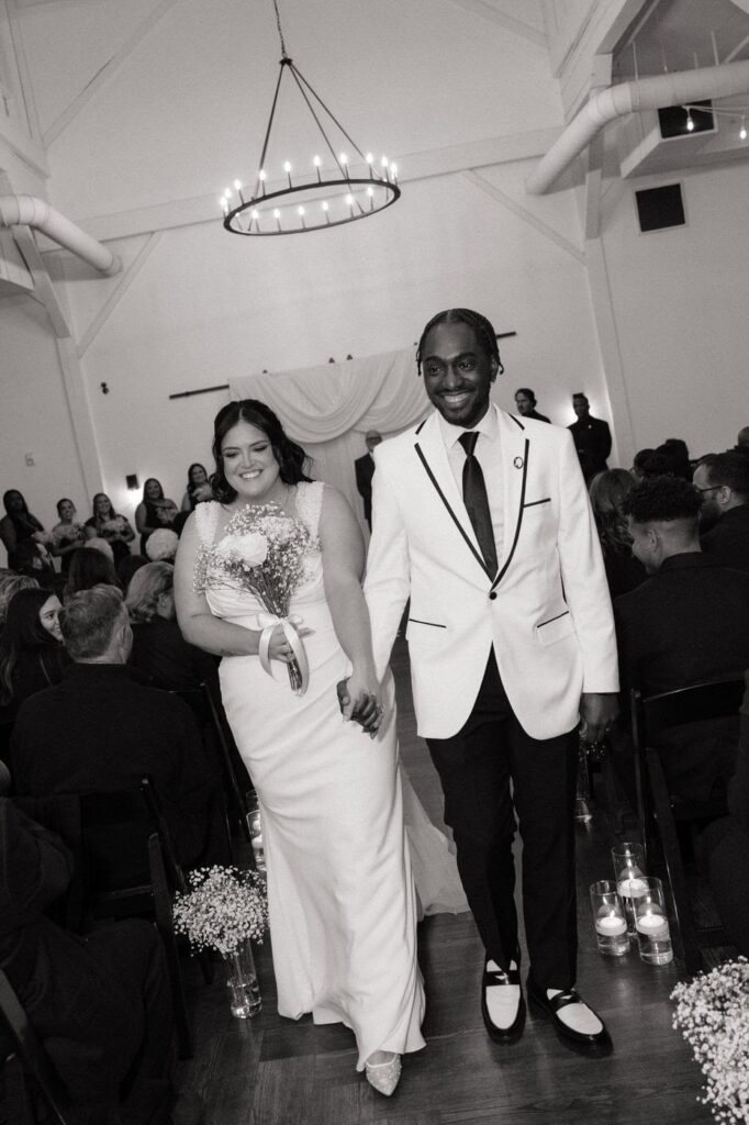 couple laughing as they walk down the aisle after wedding ceremony