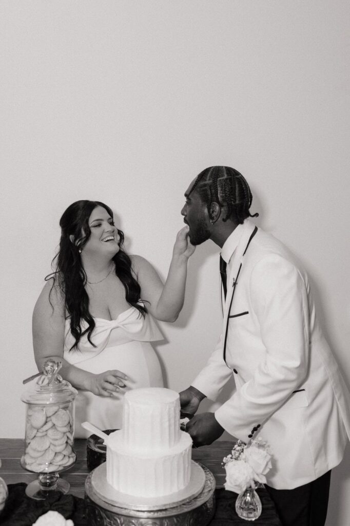 couple feeding each other cake at wedding reception in nashville