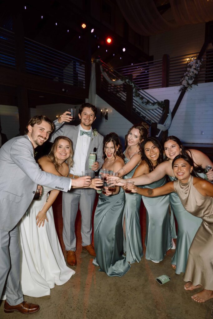 bridal party laughing and toasting at wedding reception in nashville