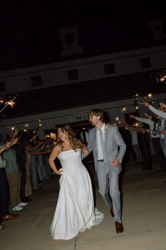 couple laughing during their sparkler exit on their wedding day