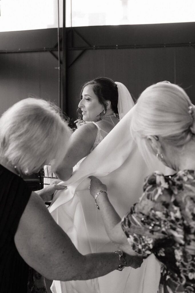 mother of the bride fixing bride's dress