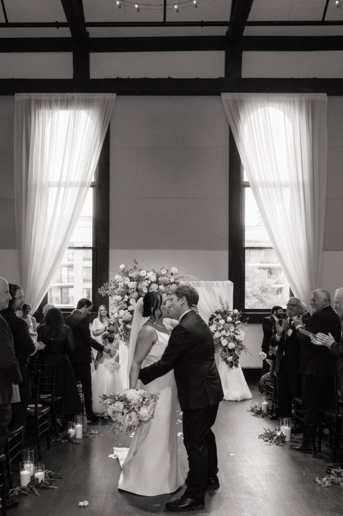 bride and groom walking back down the aisle and kissing