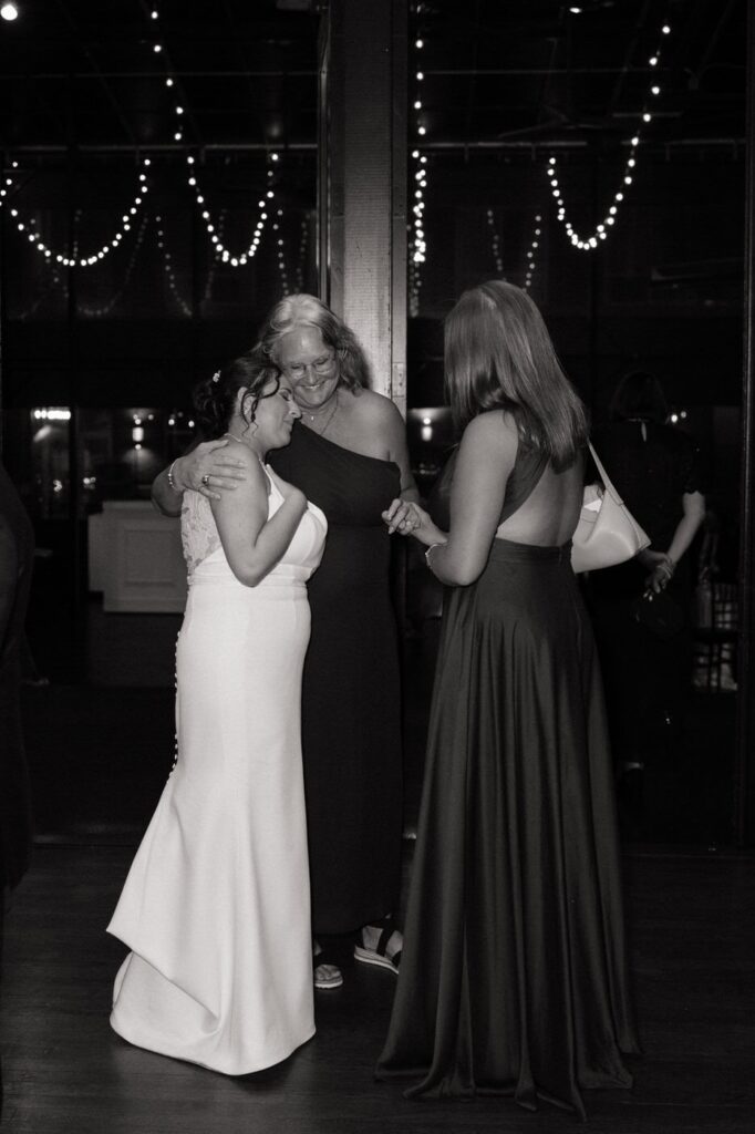 candid moment of the bride hugging guests at the reception