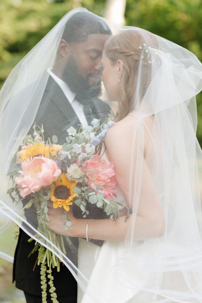 bride and groom under the veil on their wedding day outside of nashville