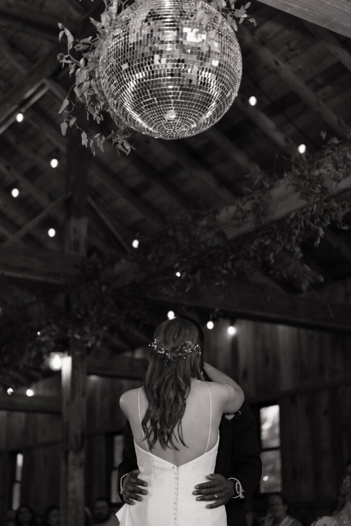 bride and groom first dance under the disco ball