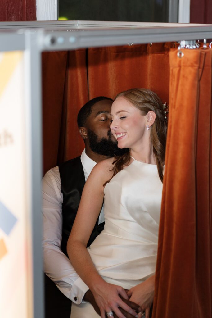 bride and groom taking photos in a vintage photo booth in nashville