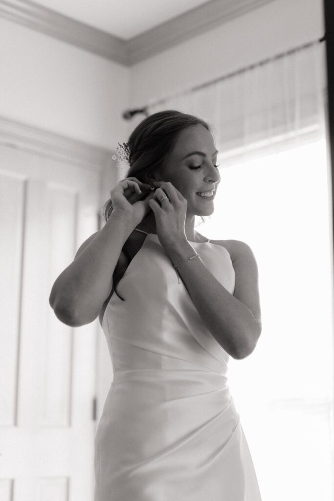 bride putting on earrings before her wedding in nashville