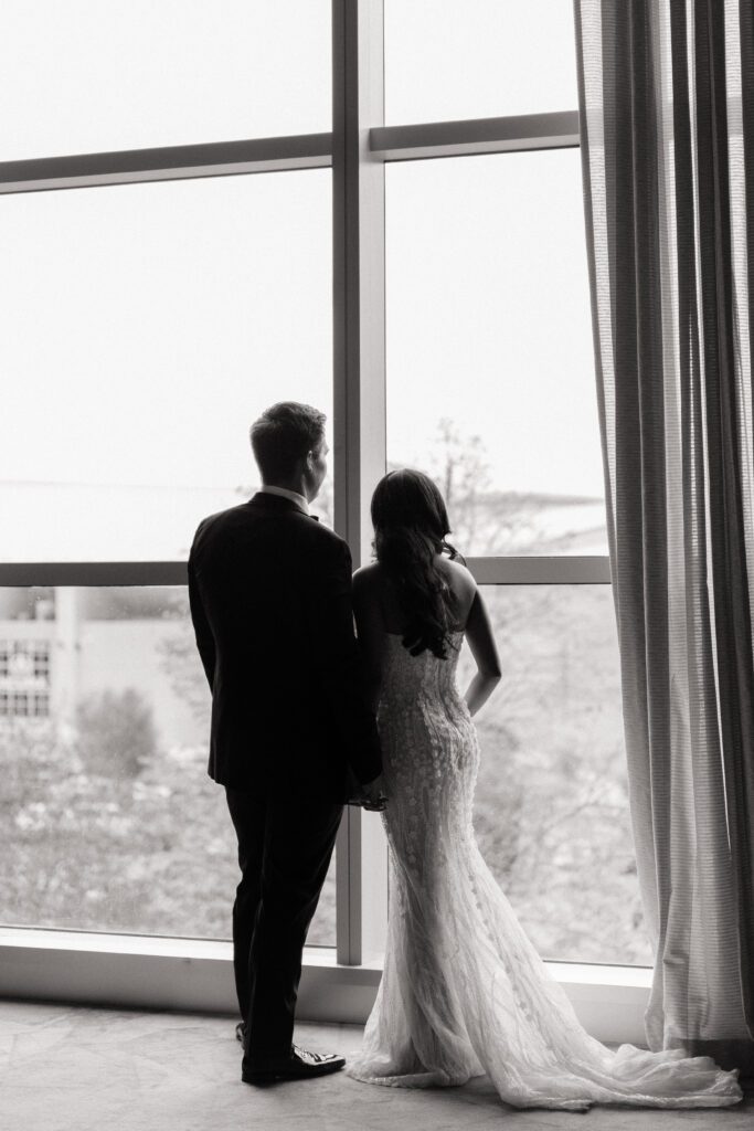 couple looking out the window at country music hall of fame wedding in nashville
