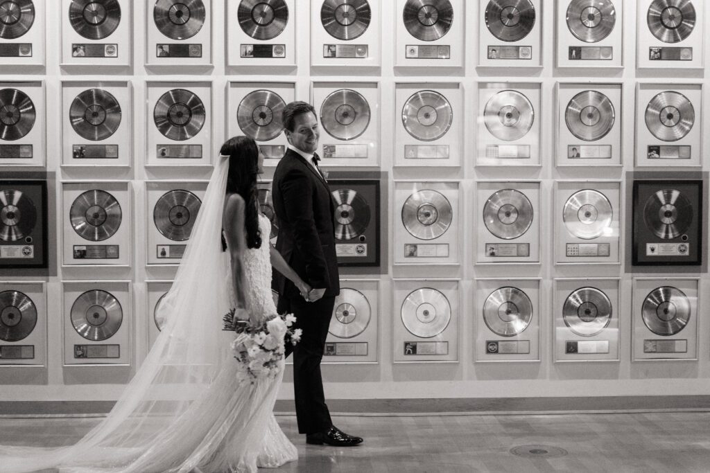 couple holding hands walking at country music hall of fame wedding