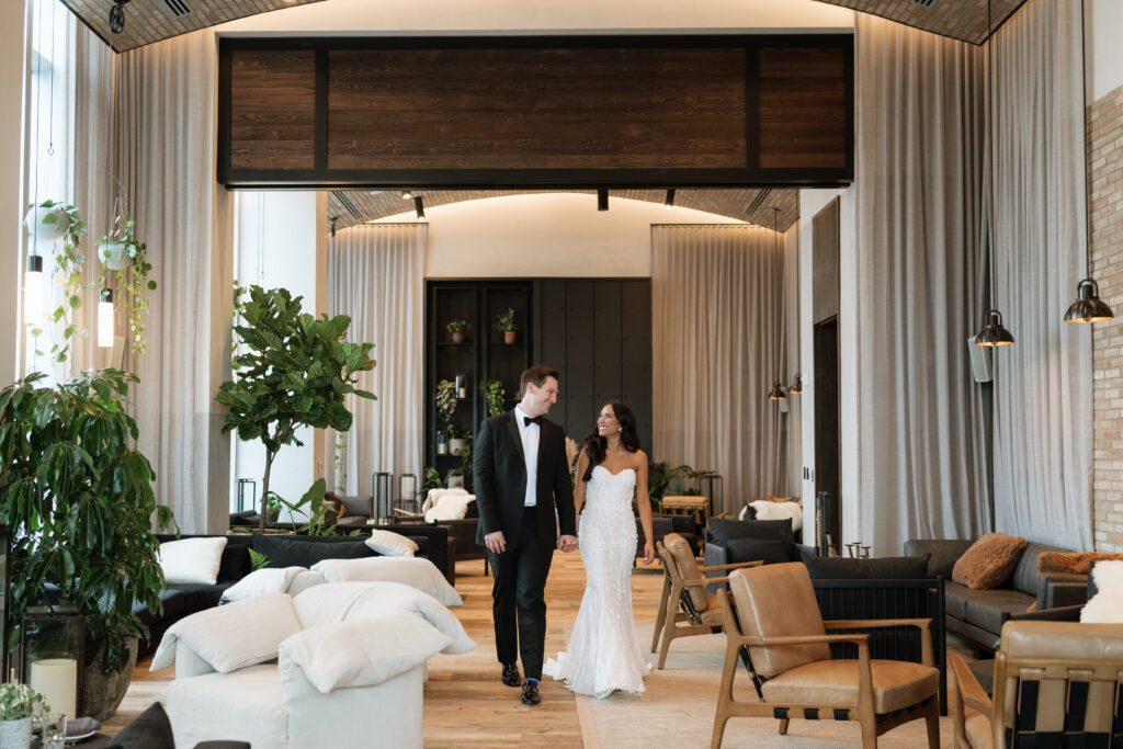 couple holding hands and walking through the 1 hotel nashville rooftop bar