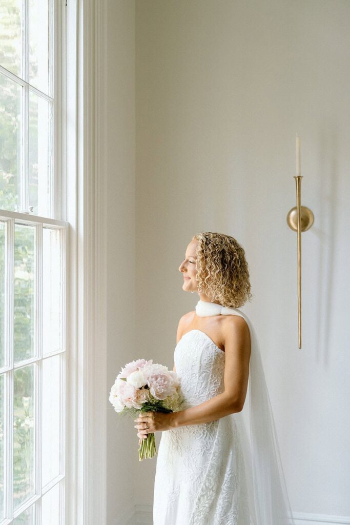 bride looking out the window at wedding venue in tennessee