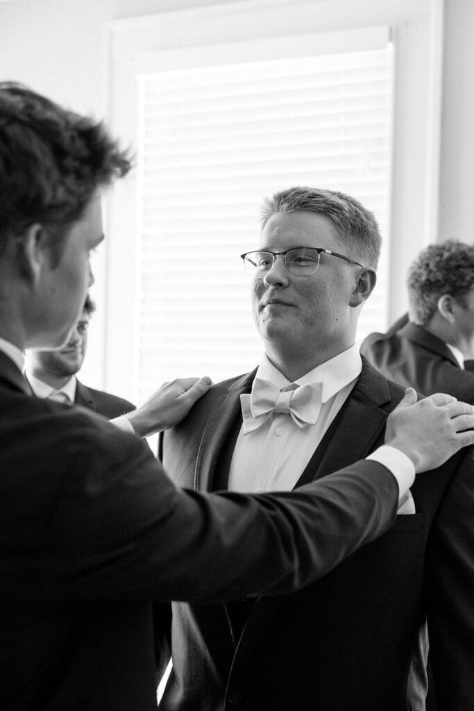 candid moment of groom and his friends getting ready on wedding day