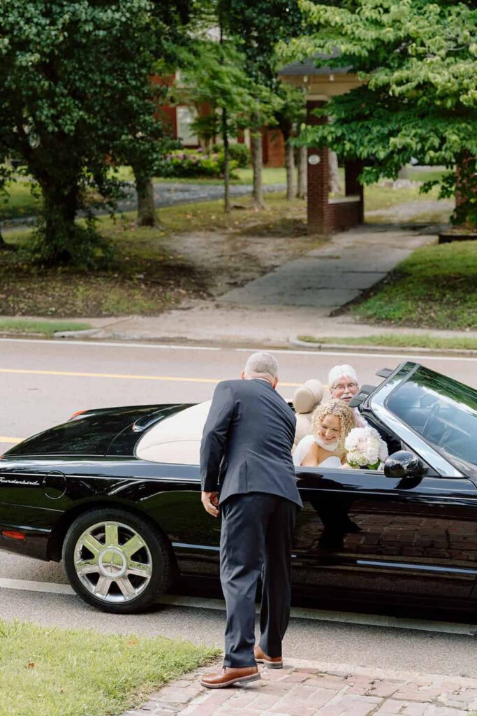 bride getting out of the car to walk down the aisle on her wedding day