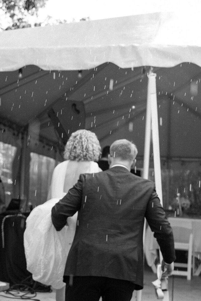 bride and groom escaping the rain at tennessee wedding venue