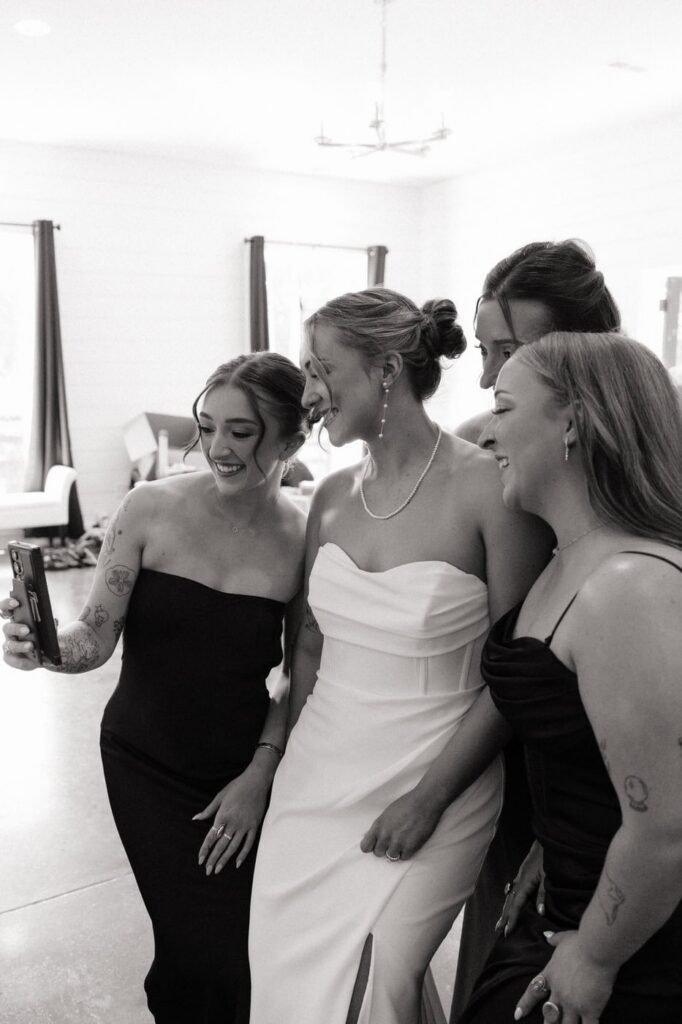 Bride laughing with bridesmaids on wedding day